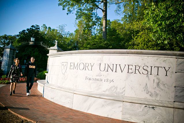 Students walk by Emory's front gate.