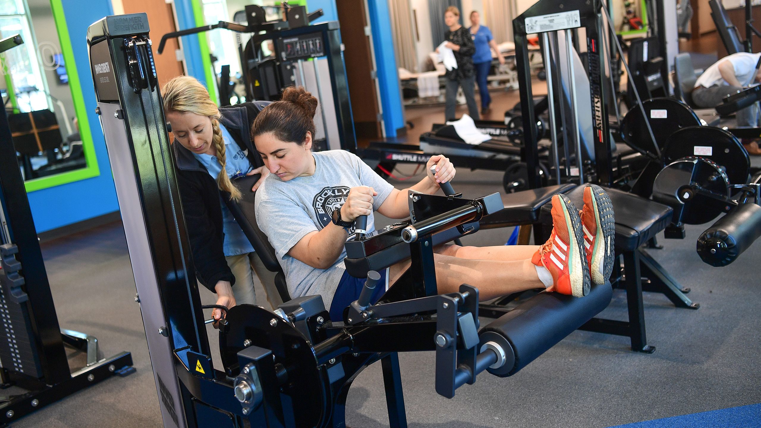 Lena Weiss works on leg extensions with physical therapist Emily Bolthouse.