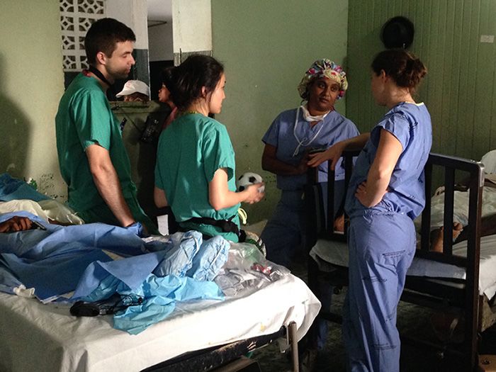 Dr. Jahnavi Srinivasan talks with other medical team members between patients at a Haitian hospital.
