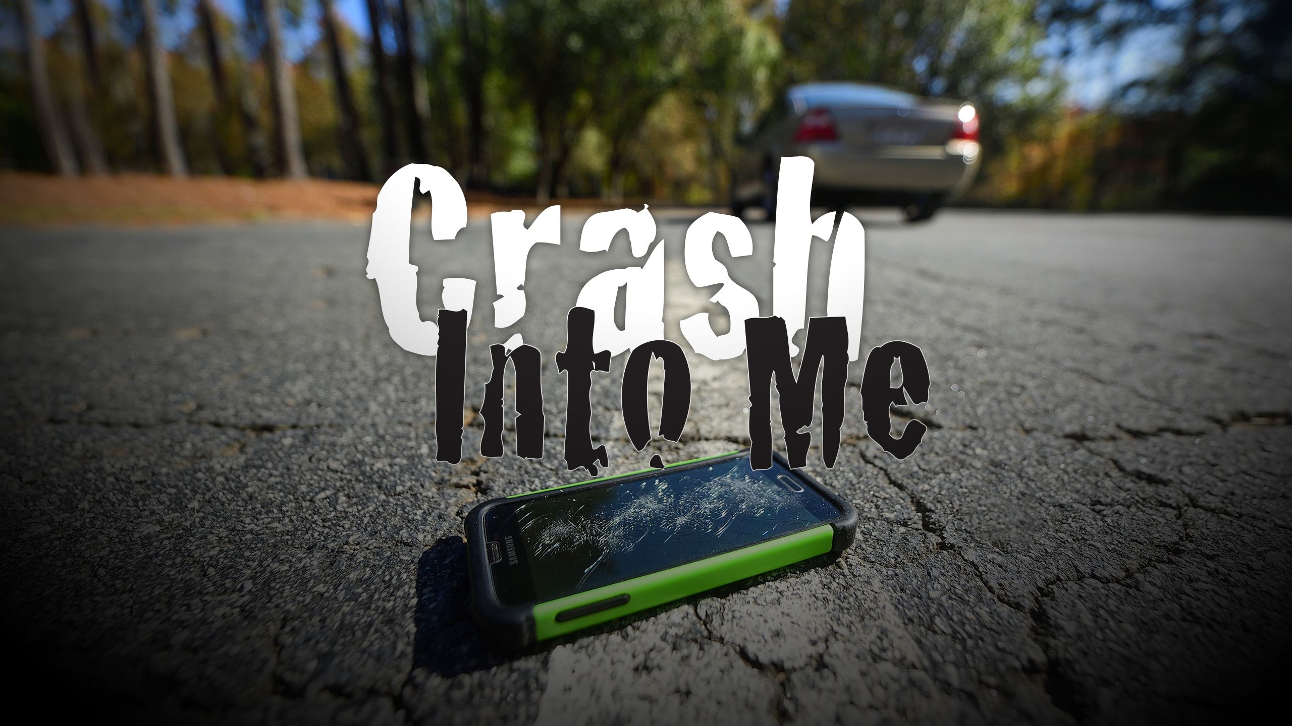Crushed cell phone lying in the middle of a road as a photo illustration with the words "Crash Into Me" over it.