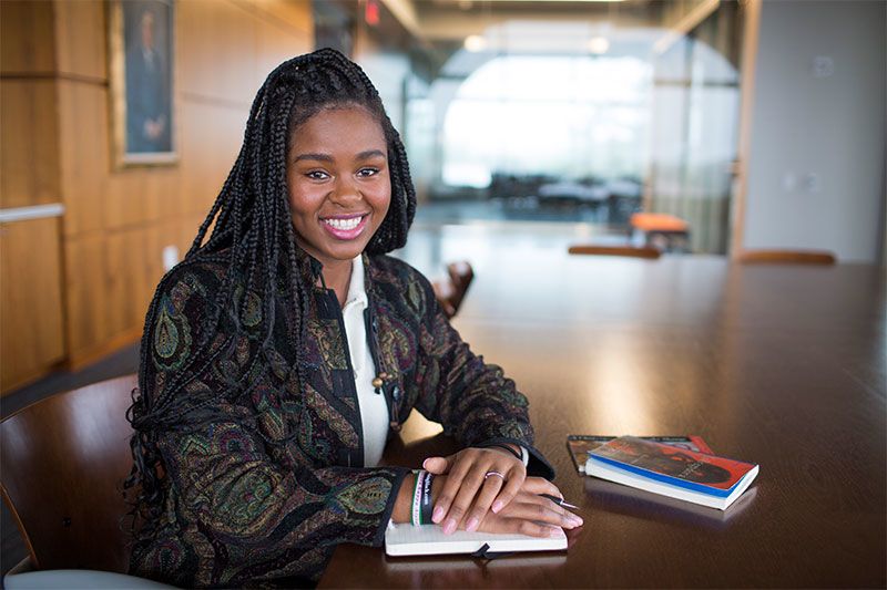 Christell Victoria Roach sits at a table with books in Emory's Rose Library