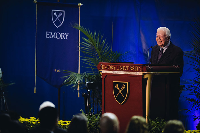 President Jimmy Carter stands smiling at the podium.
