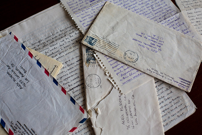 Several other letters and their envelopes sit, fanned out on a table.
