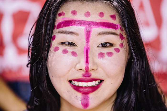 A student dons fuchsia face paint