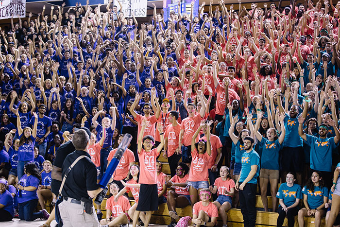 Students in many colors cheer from the stands at Songfest