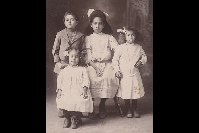 Three girls and one boy pose for a photo