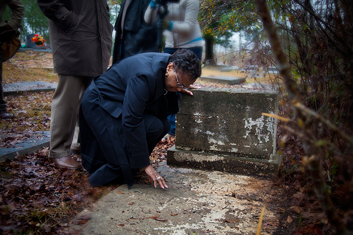 Seeing her father's grave for the first time, Dorothy Nixon Williams bent to touch the marker etched with his name before weeping in the arms of her son.