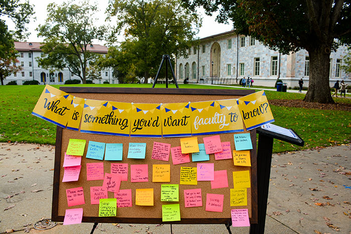A bulletin board with colorful sheets of paper on it reads, "What is something you'd want faculty to know?"