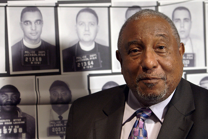Bernard LaFayette speaks to the camera during a filming for the course at the Center for Civil and Human Rights. His mugshot, taken after his arrest during the Freedom Rides in June 1961, appears in the top row at the far left of this image. 