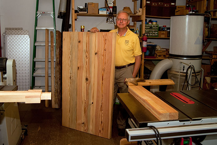 Dean Bowen displays the table top, constructed from heart pine salvaged from an original floor beam in Phi Gamma Hall.