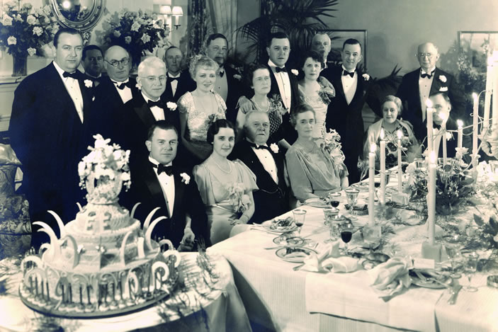 Emily Winship Woodruff, far right, first row, seated at a gala affair next to husband Ernest  and in front of son Robert Woodruff, standing.