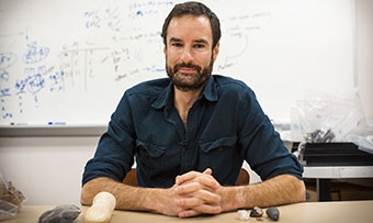 Justin Pargeter poses with various rocks that could have been 'tiny tools'