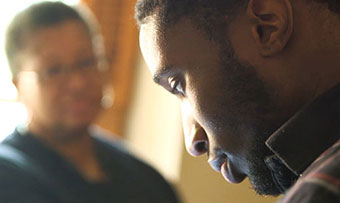 A young man speaks to a woman