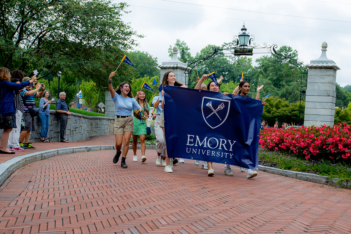 college students walking through the gate to Emory University campus
