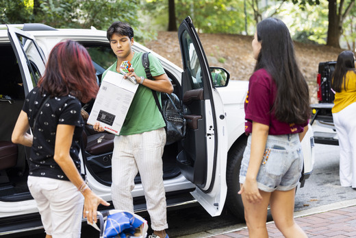 Student unloading a van with boxes