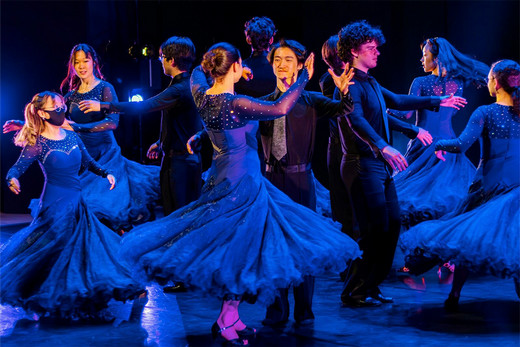 Emory's ballroom dancing club in blue gowns on a stage