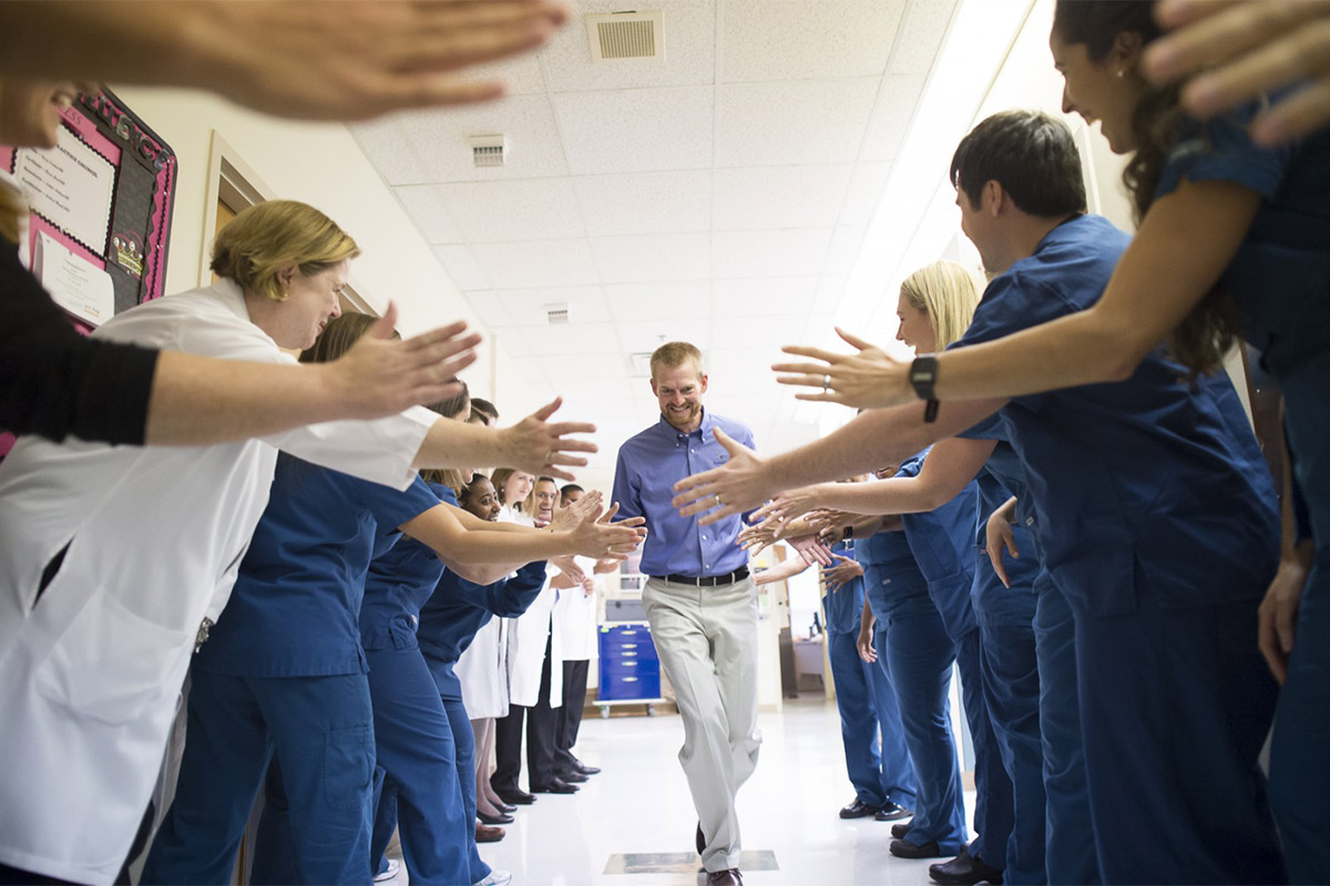 Healthcare workers high-five patient Kent Brantly after he was successfully treated for Ebola virus disease in 2014