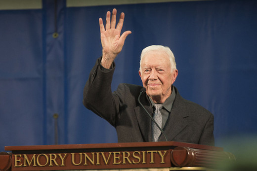 President Jimmy Carter waves from behind a speaker podium