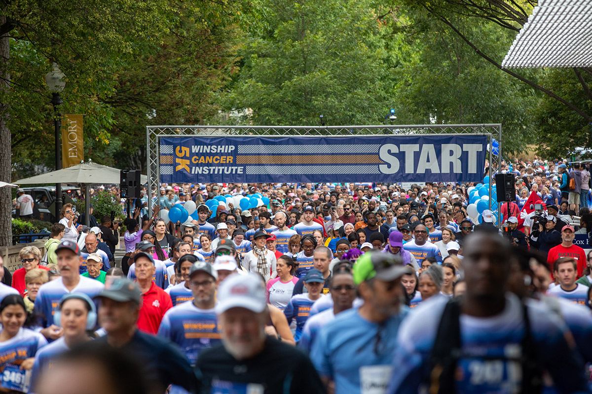 large crowd of people at the starting banner for a race