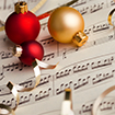 red and gold Christmas ornaments on top of sheet music