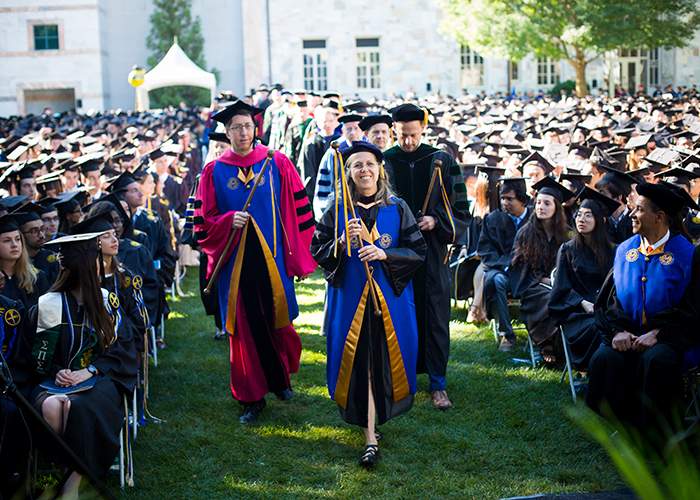 Faculty Marshal Kristin Wendland (center), senior lecturer in music, leads the faculty in the procession.