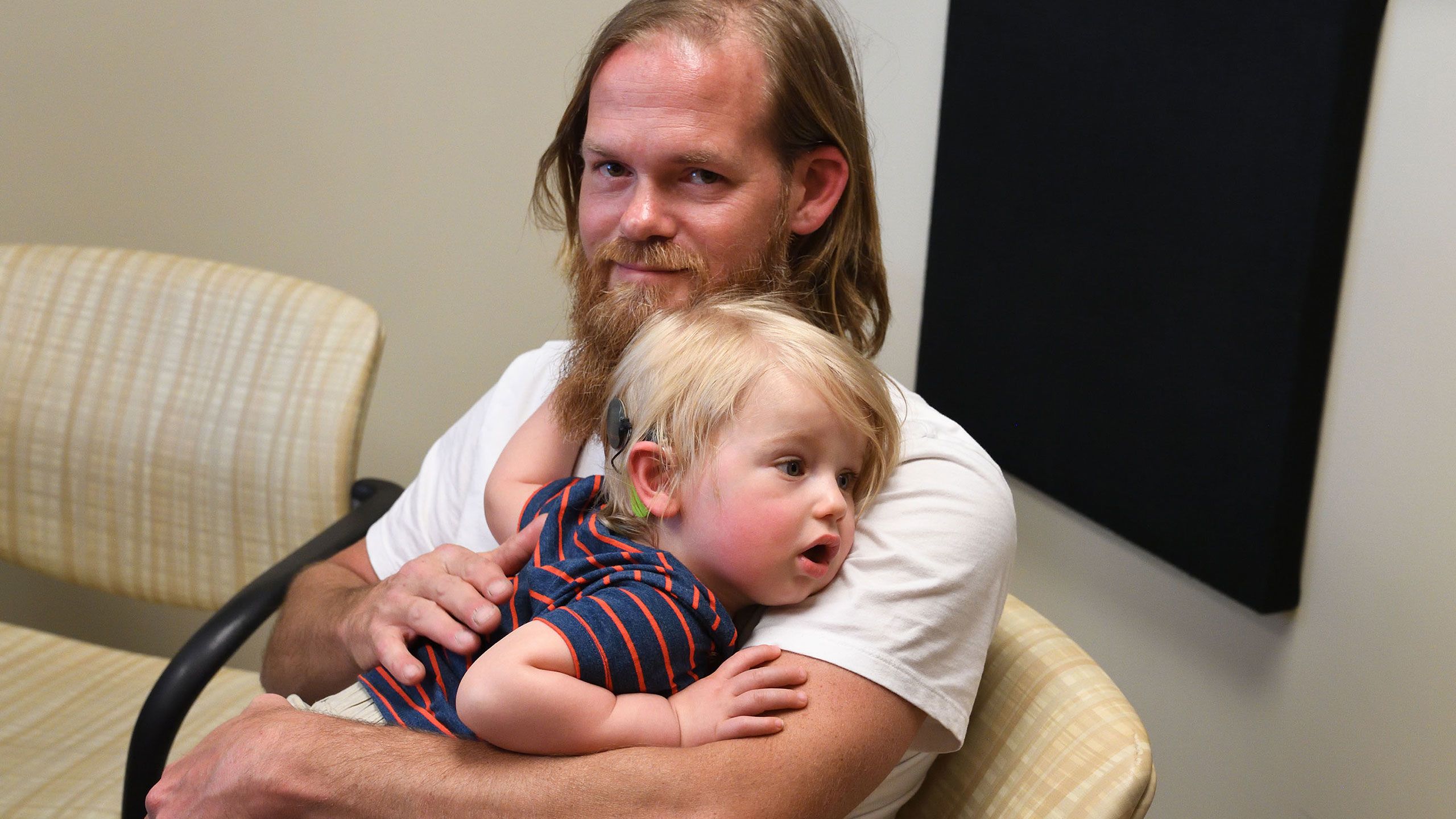 Randy Adams holds his toddler son, Maxwell Adams, in an Emory physician's office.