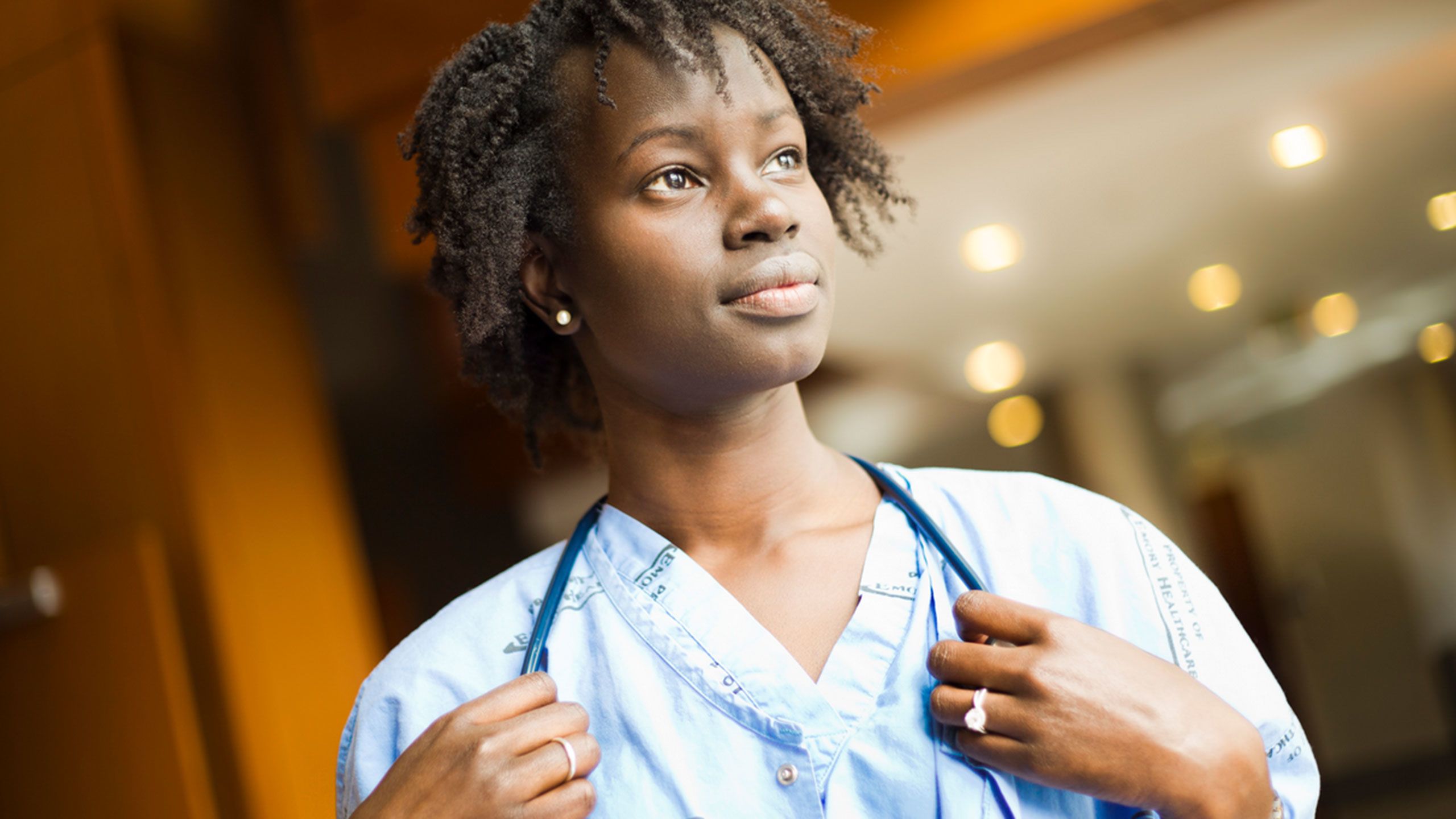 Lurit Bepo poses in scrubs, holding her stethoscope.