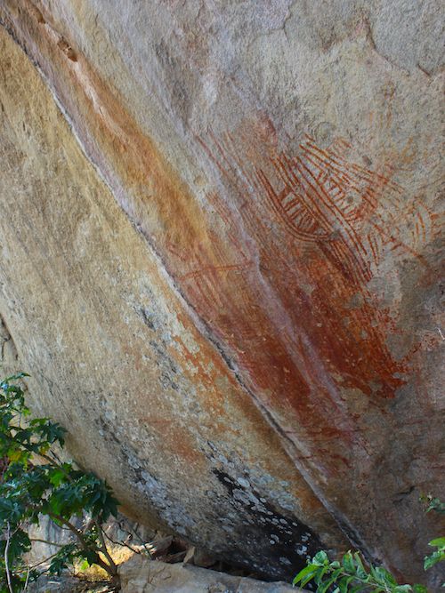 A large rock shows line drawings on its surface.