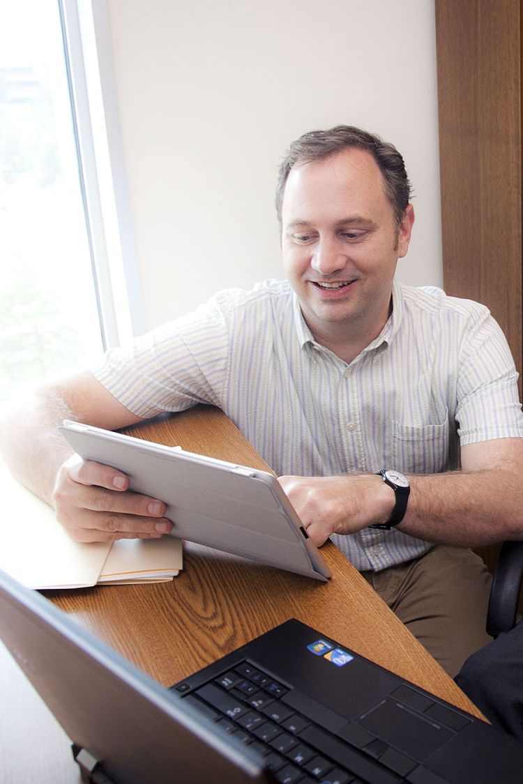 Rollins researcher shows HIV study findings on his laptop.