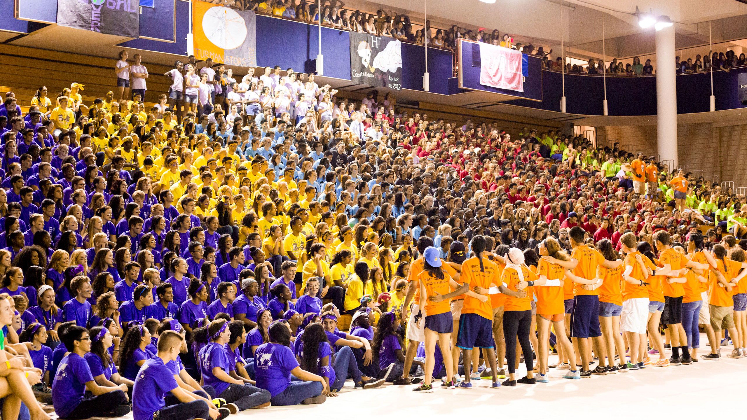 Students in brightly colored t-shirts fill the stands in the Woodruff PE Center.
