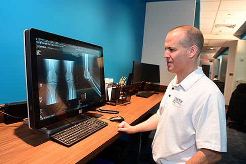 Dr. Kenneth Mautner looks at patient X-rays on a monitor.