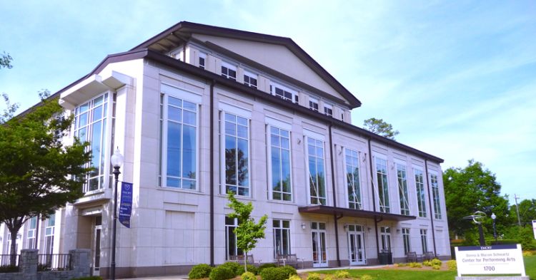 An exterior image of the Schwartz Center for Performing Arts on the Emory University campus. The building has large front windows facing the street.