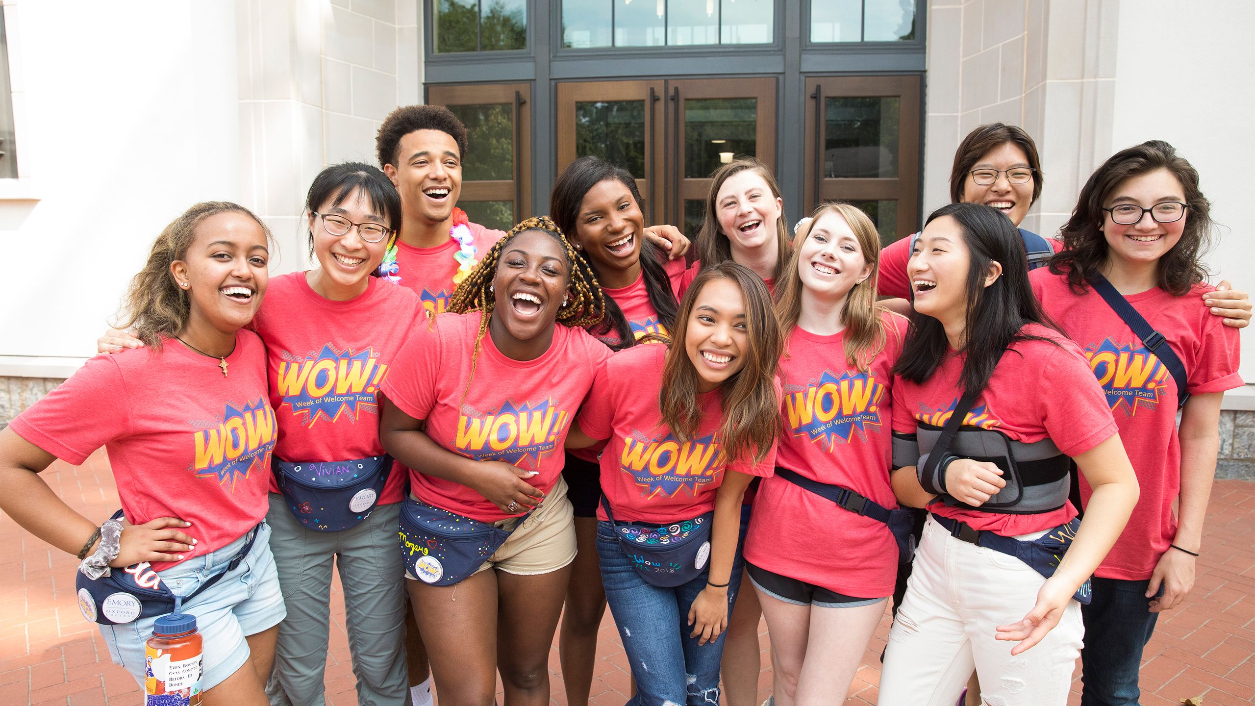 Student volunteers in red t-shirts smile and laugh as they greet the Class of 2022.