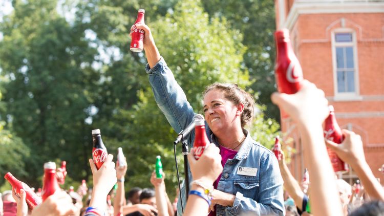 Students raise Coca-Cola aluminum bottles in the air for the Coca-Cola Toast, a tradition of welcoming new students to Emory.