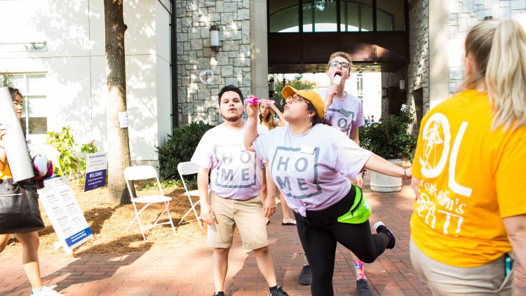 Student volunteers blow bubbles as they welcome the Class of 2022 to the Emory campus.