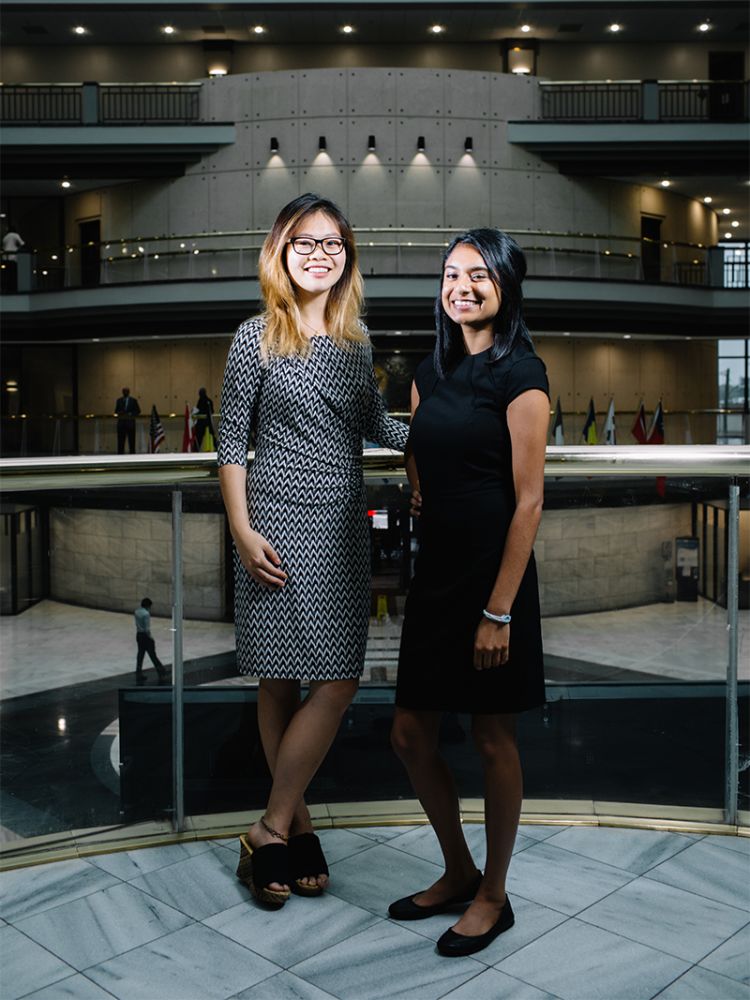 Angela Jiang and Tarunika stand on an inside balcony overlooking the lobby of Atlanta City Hall.