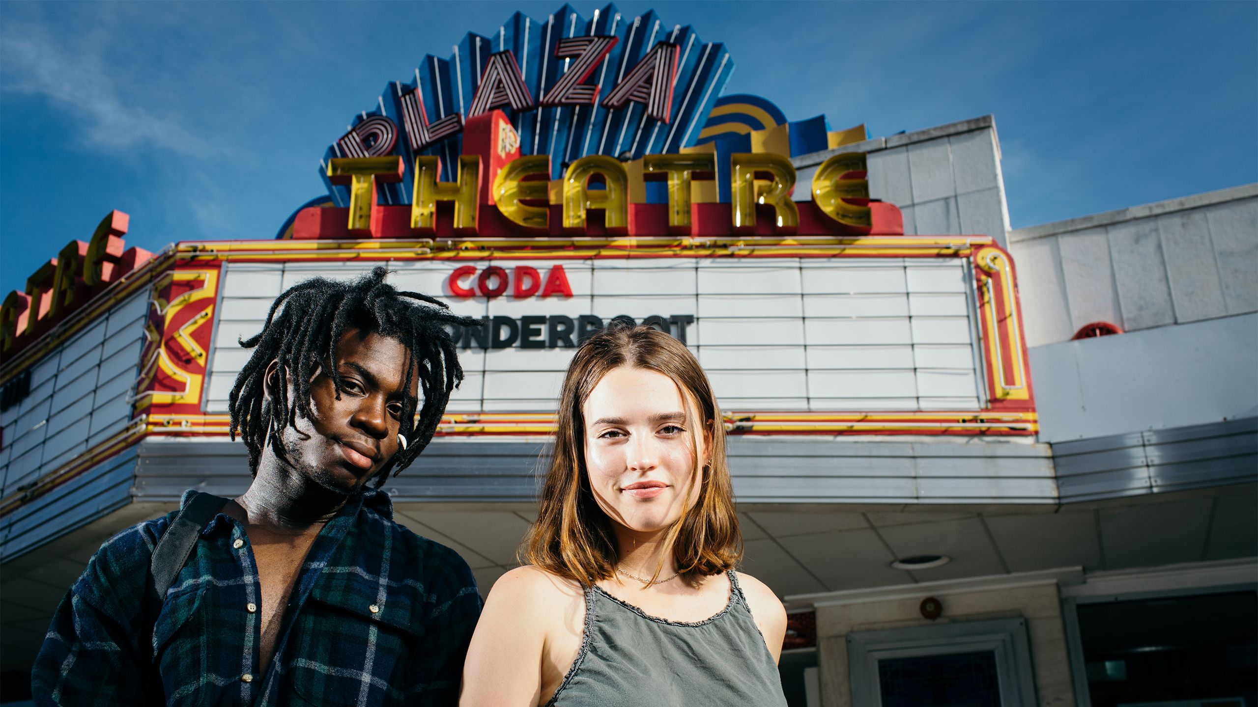 Jard Lerebours and Michelle Baltrusitis stand in front of the marquee of Atlanta's Plaza Theatre.
