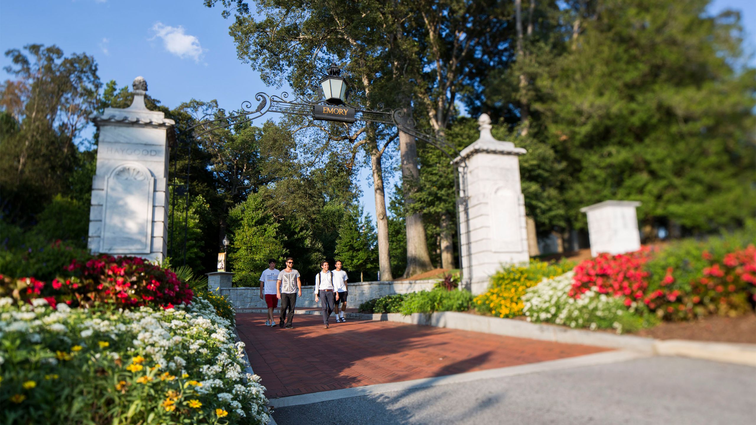 Students walk under the Emory gate onto campus
