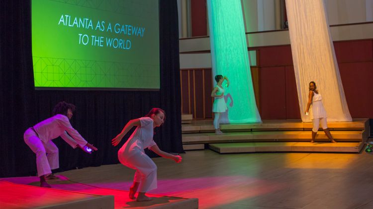 Four student dancers dressed in white hold glowing orbs representing the four pillars