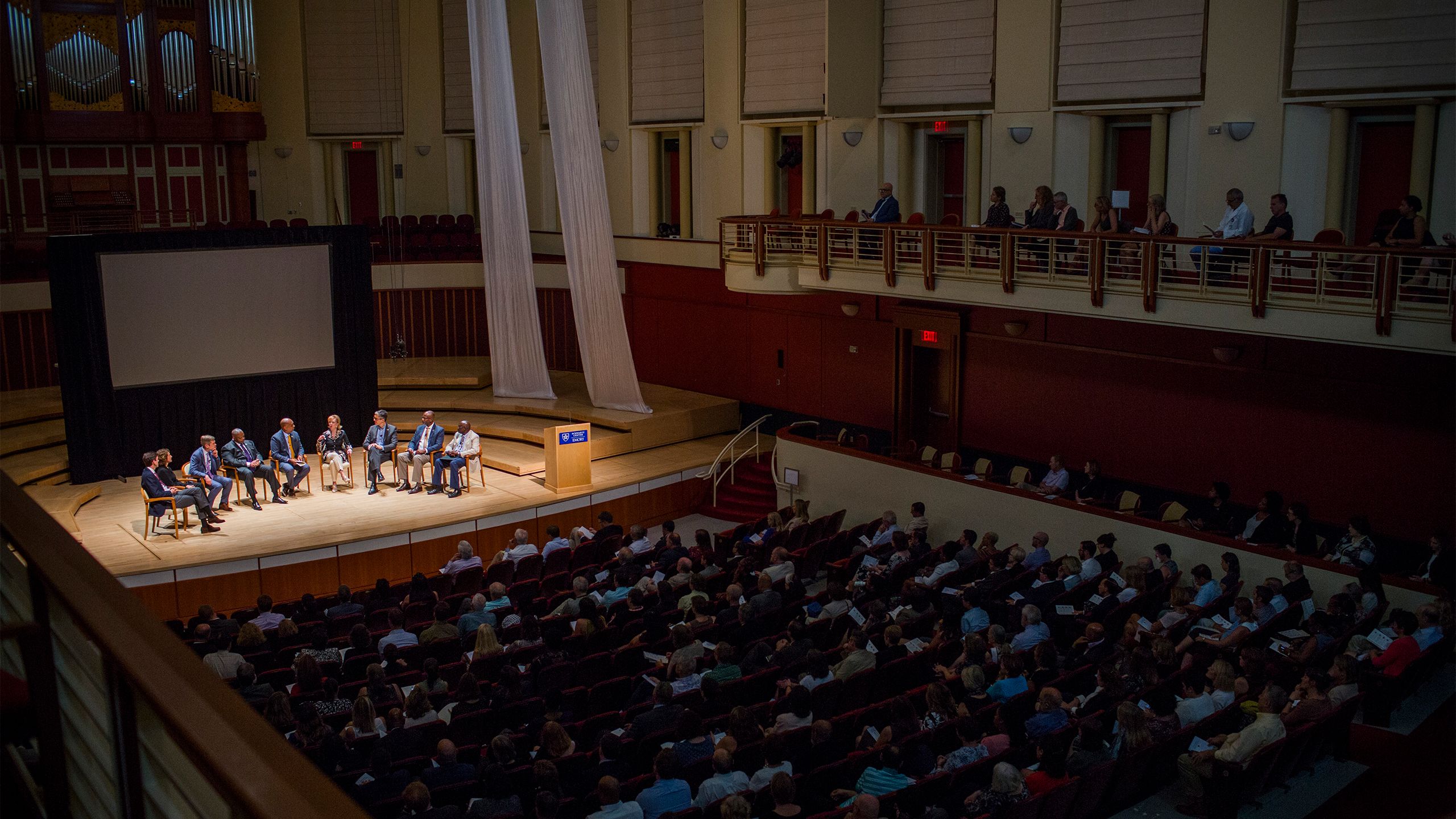 Emory's Schwartz Center for Performing Arts is filled to capcity as a panel of faculty sit on stage.