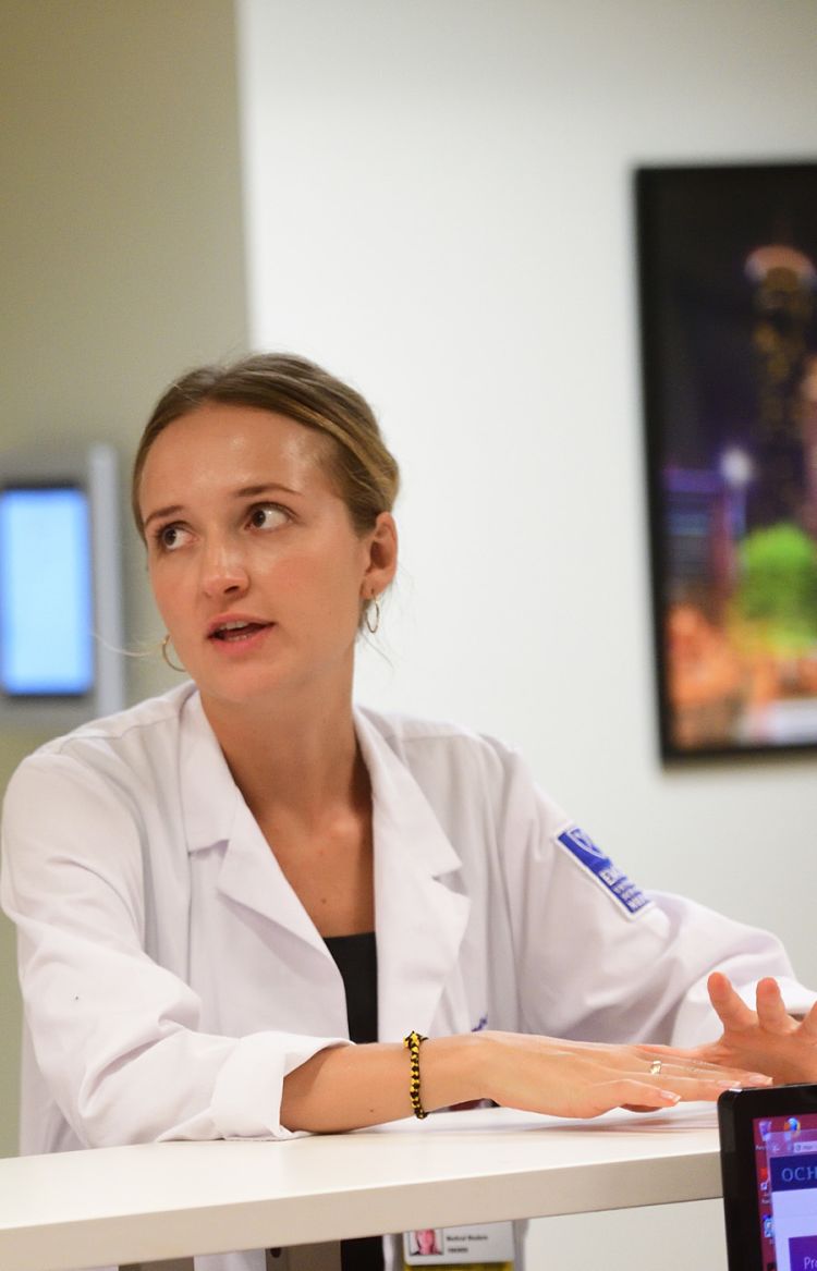 An Emory medical student is briefed on a case at Gateway Clinic.