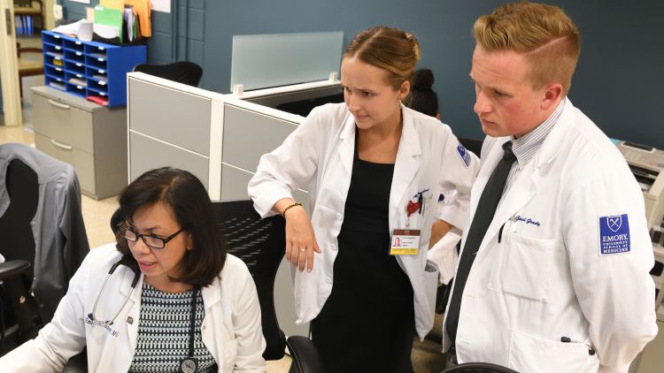 Emory medical students talk about a patient case with their faculty mentor at Gateway Clinic. 