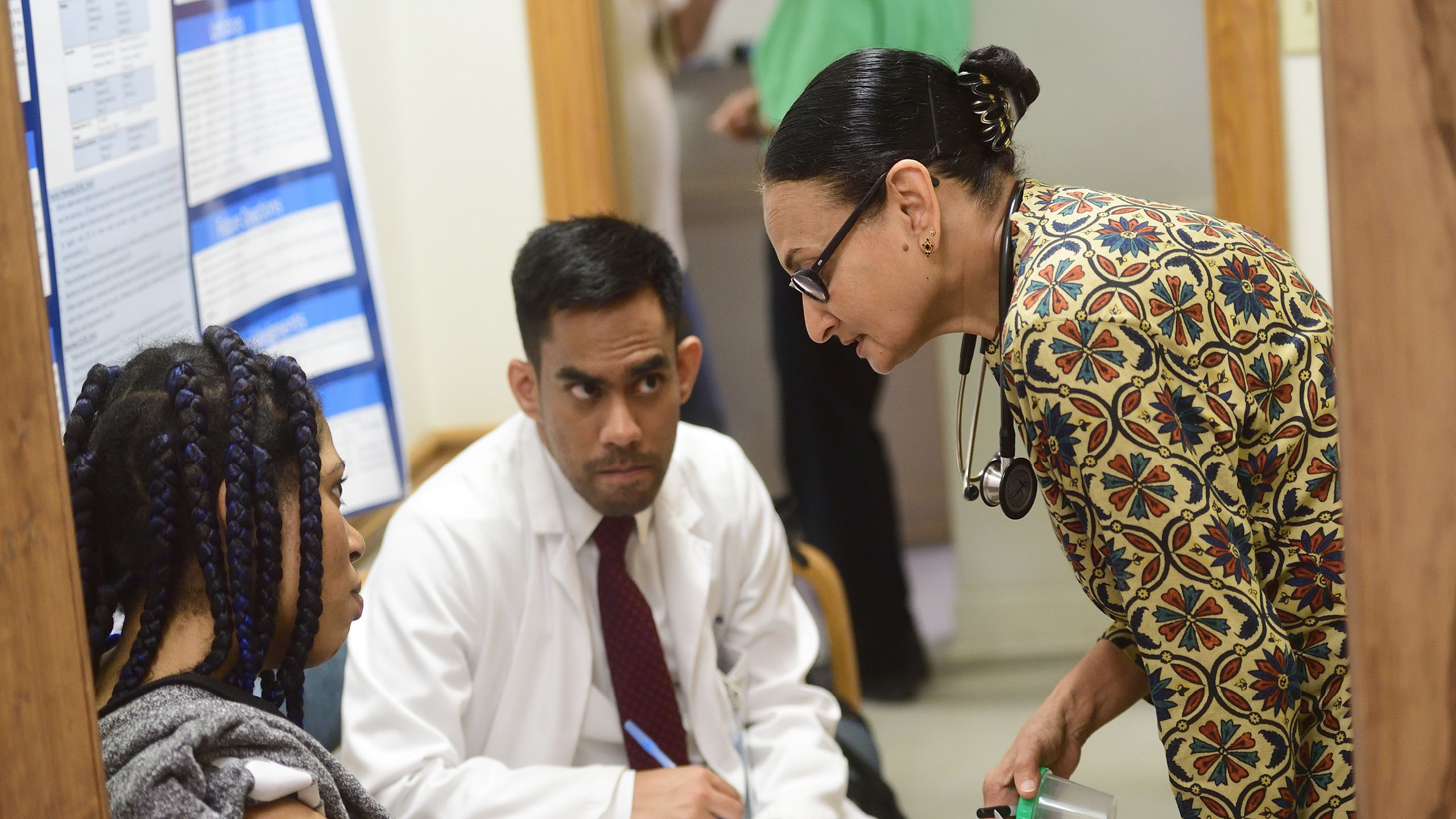 An Emory medical student talks with a doctor and a patient at the Clarkston clinic.