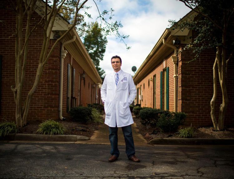 Dr. Heval Kelli, Emory medical alumnus and cardiology fellow, standing outside a clinic. 