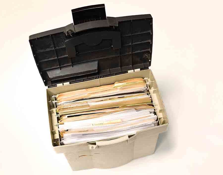 A plastic file box filled with papers on transgender health.        
