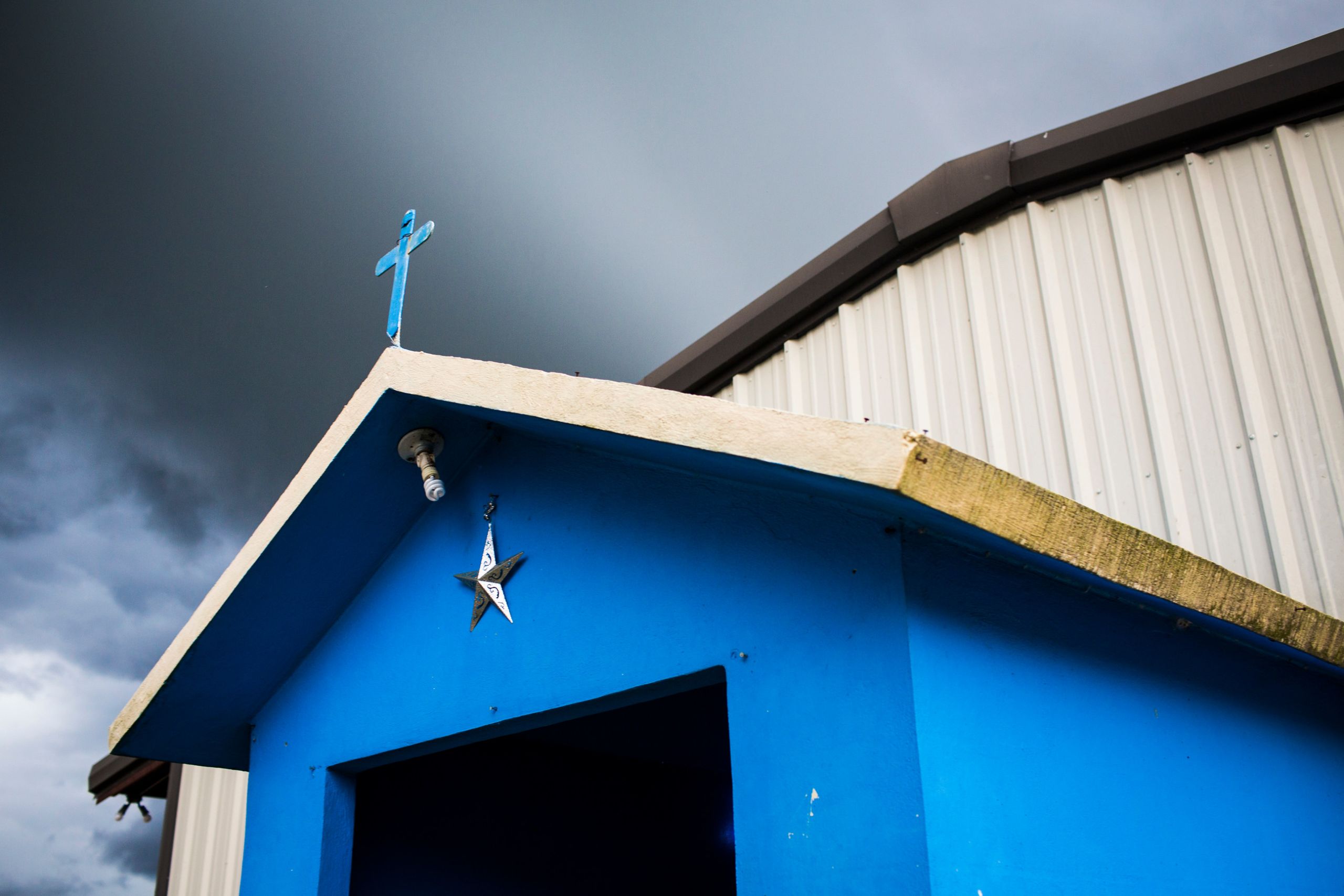 Farmworkers built a blue chapel outside their barracks at Lewis Taylor Farms