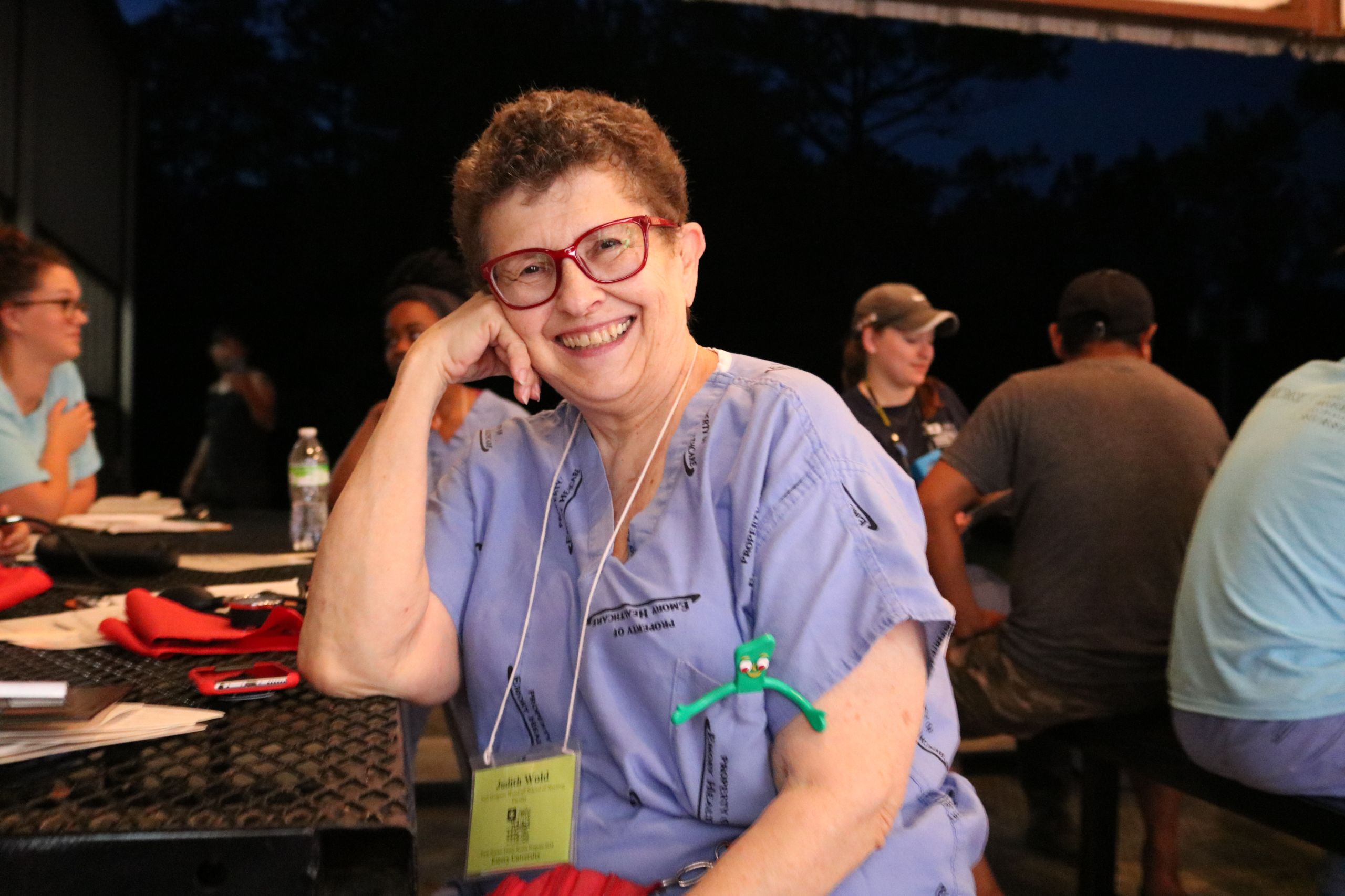 Judith Wold sits, smiling at a picnic table