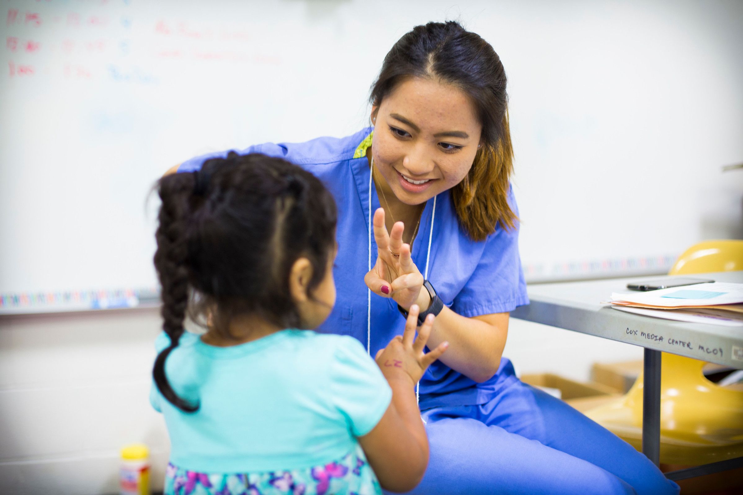An Emory nursing student works with a Cox Elementary student