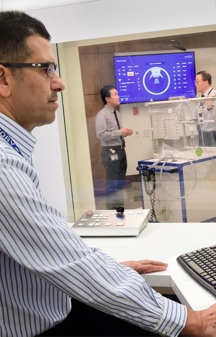 Medical physicists are seen getting the system ready to start treating patients.