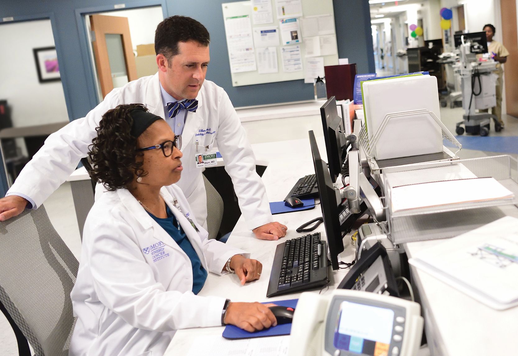 image of hemologist William Blum with Winship staff member looking at a computer screen in the hospital